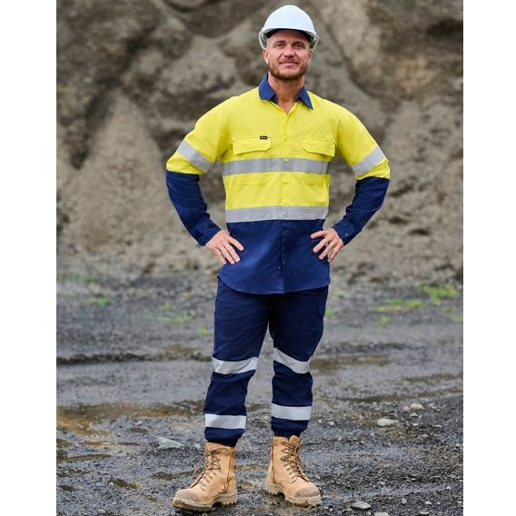 Person wearing a high-visibility safety outfit with reflective stripes in an outdoor setting.