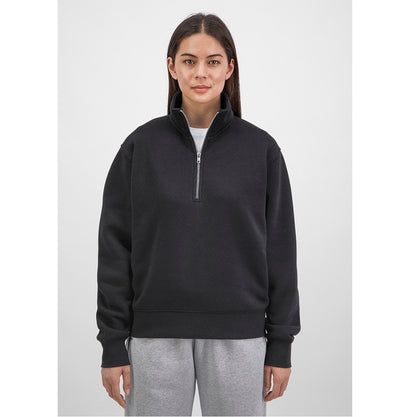 Person wearing a black half-zip sweatshirt and gray pants on a white background