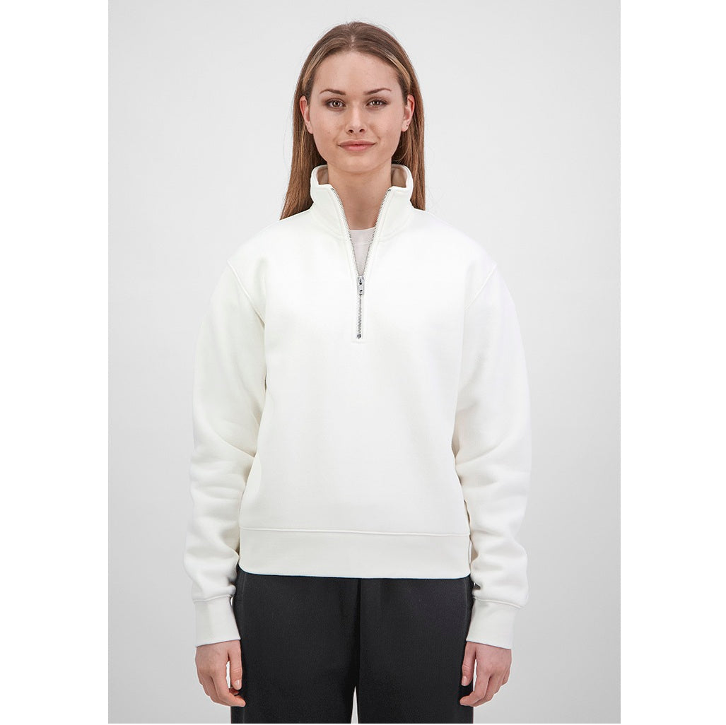 Woman wearing a white half-zip sweatshirt on a light gray background