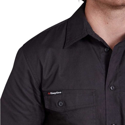 Black shirt with a logo on the chest pocket against a white background