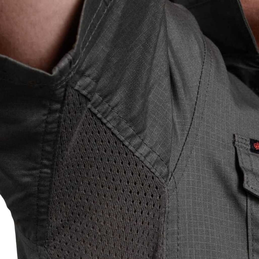 Close-up of a gray shirt with a pocket and mesh panel on a blurred background