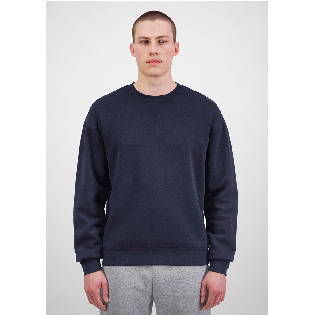 Person wearing a navy blue sweatshirt and gray pants on a white background
