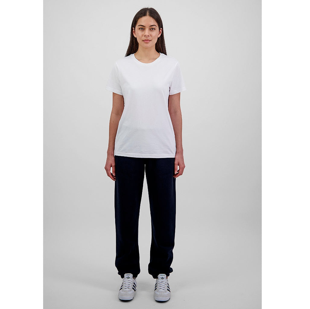 Person wearing a white t-shirt and black pants on a gray background