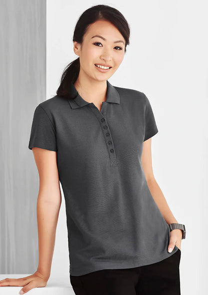 Professional woman wearing a grey polo shirt against a white background