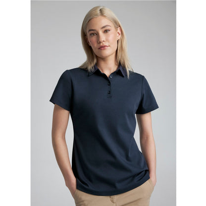 Woman wearing a navy blue polo shirt against a gray background