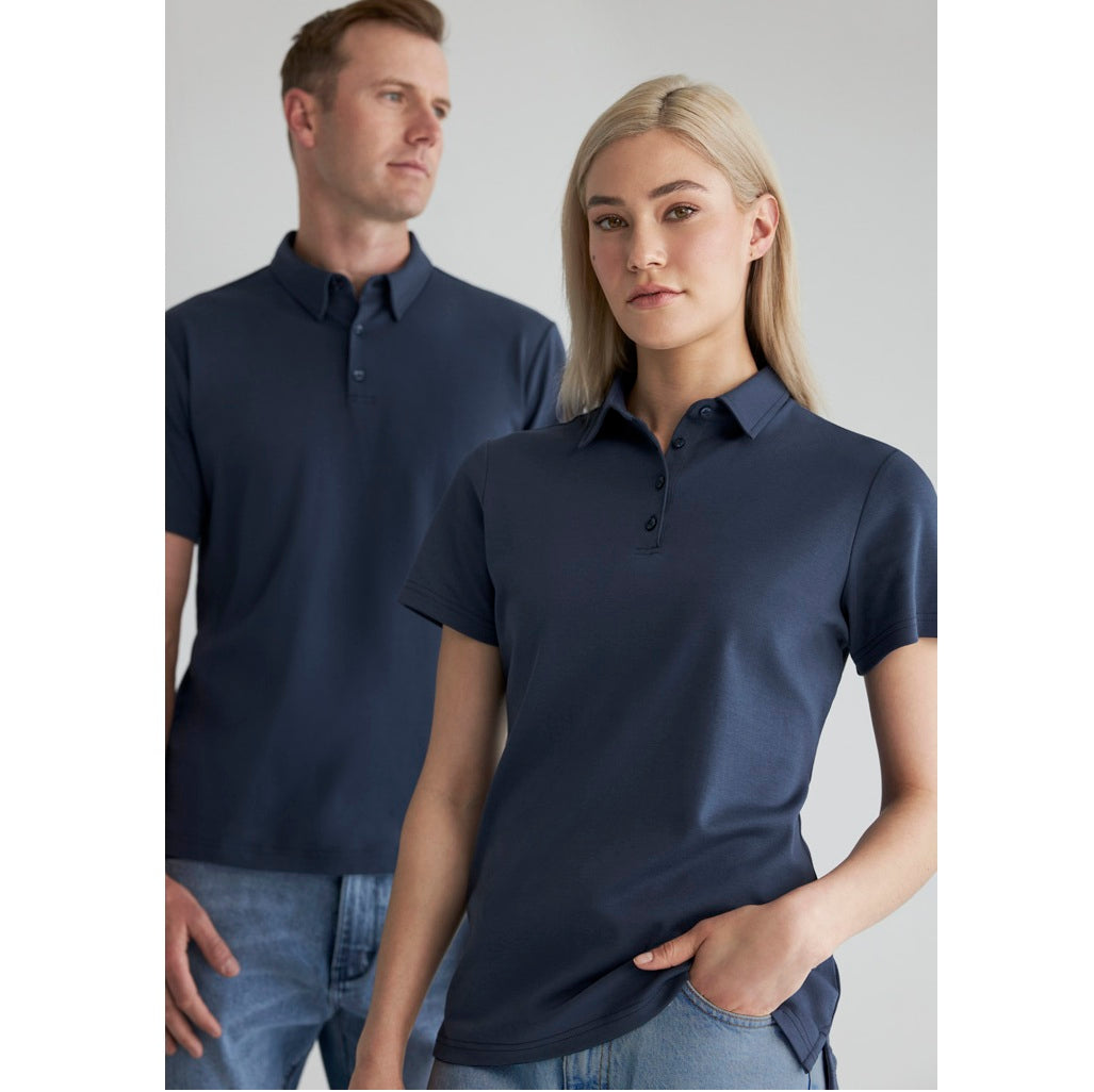 Man and woman wearing navy blue polo shirts against a plain background