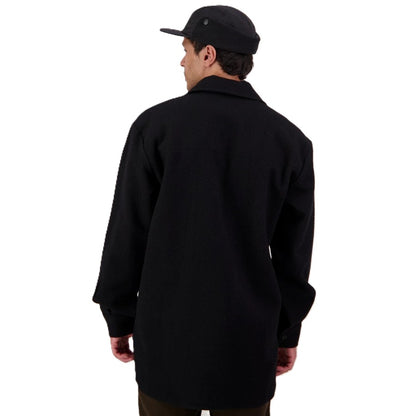 Person wearing a black coat and cap on a white background