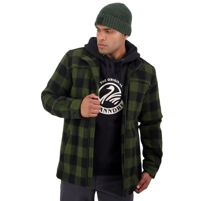 Man wearing a green and black plaid jacket over a black hoodie with a logo, on a white background.