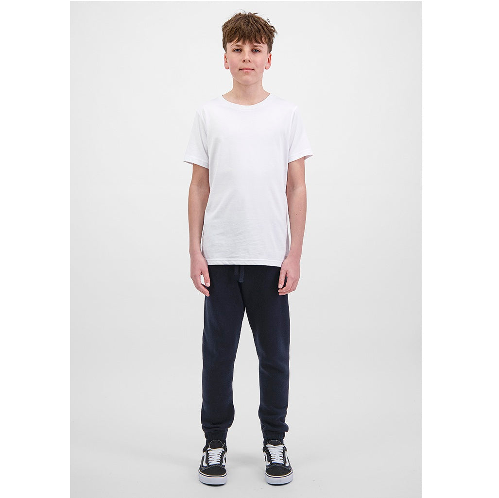 Person wearing a white t-shirt and dark pants on a plain background