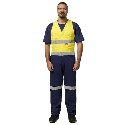 Person wearing a yellow and navy safety work coveralls on a plain background
