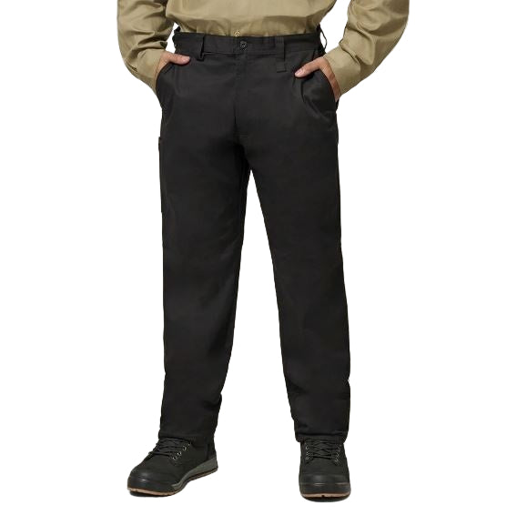 Person wearing black pants and a beige shirt on a plain background
