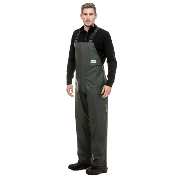Man wearing green bib overalls on a white background
