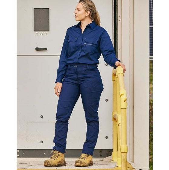Bisley Woman working, wearing a blue work uniform with women's Bisley work pants