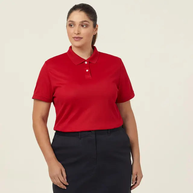 Corporate woman wearing a red polo work shirt and black skirt on a beige background