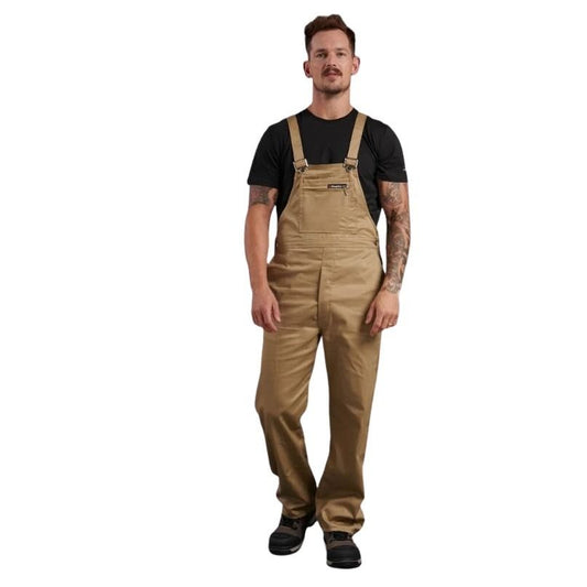 Man wearing tan bib overalls on a white background