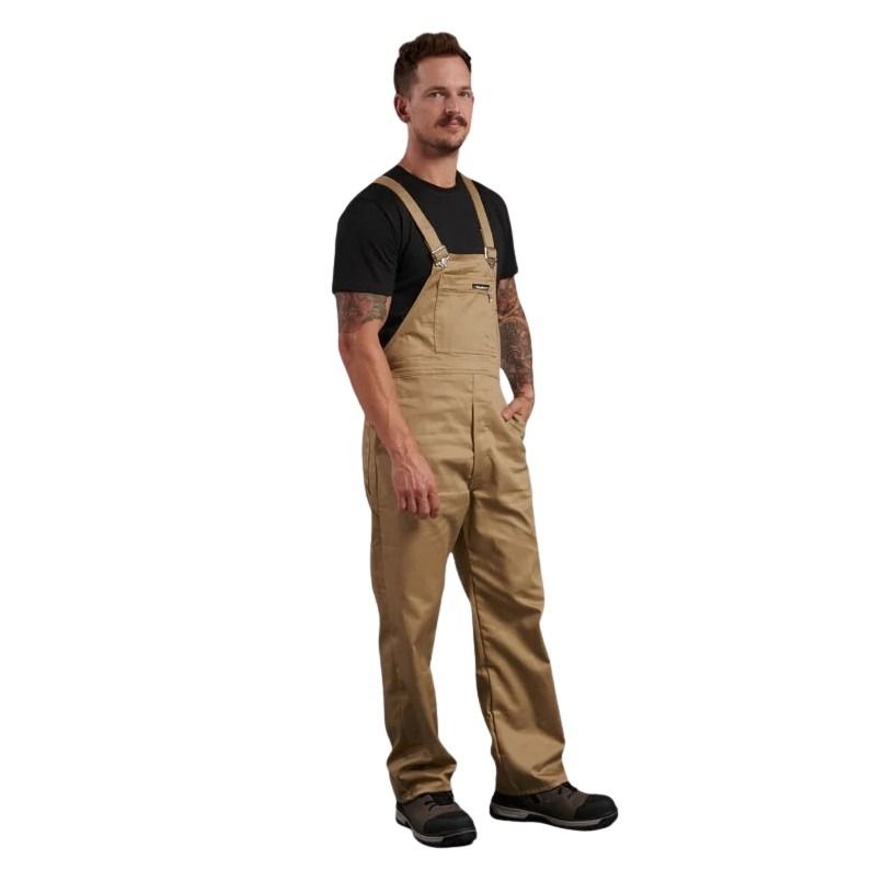Man wearing tan bib overalls on a white background
