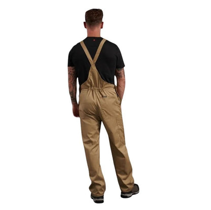 Person wearing beige overalls and a black shirt on a white background