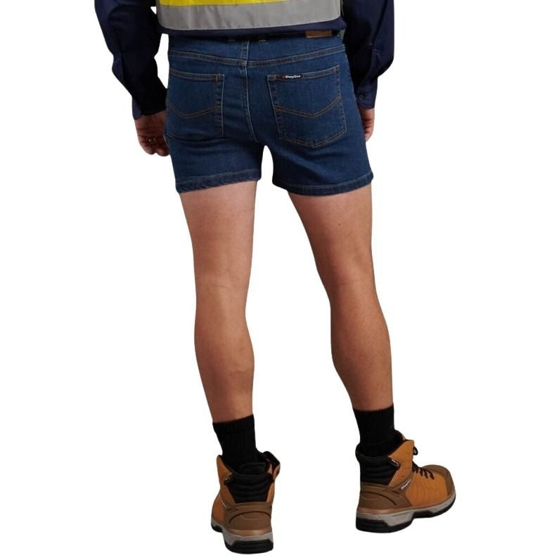 Person wearing blue denim shorts, brown work boots, and a high-visibility safety vest on a white background