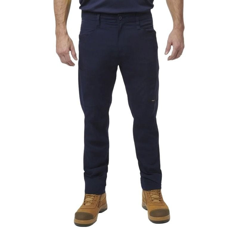 Person wearing navy pants and brown boots on a white background