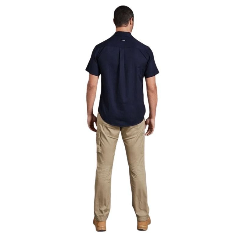 Man wearing a navy shirt and beige pants on a white background