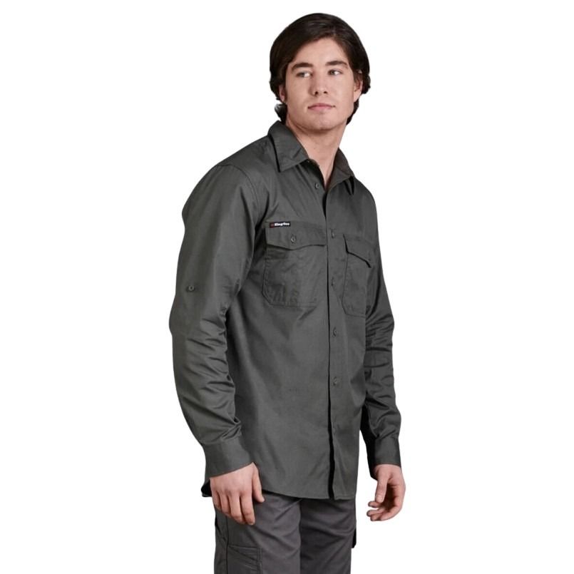 Man wearing a dark gray shirt with a visible brand logo on a white background