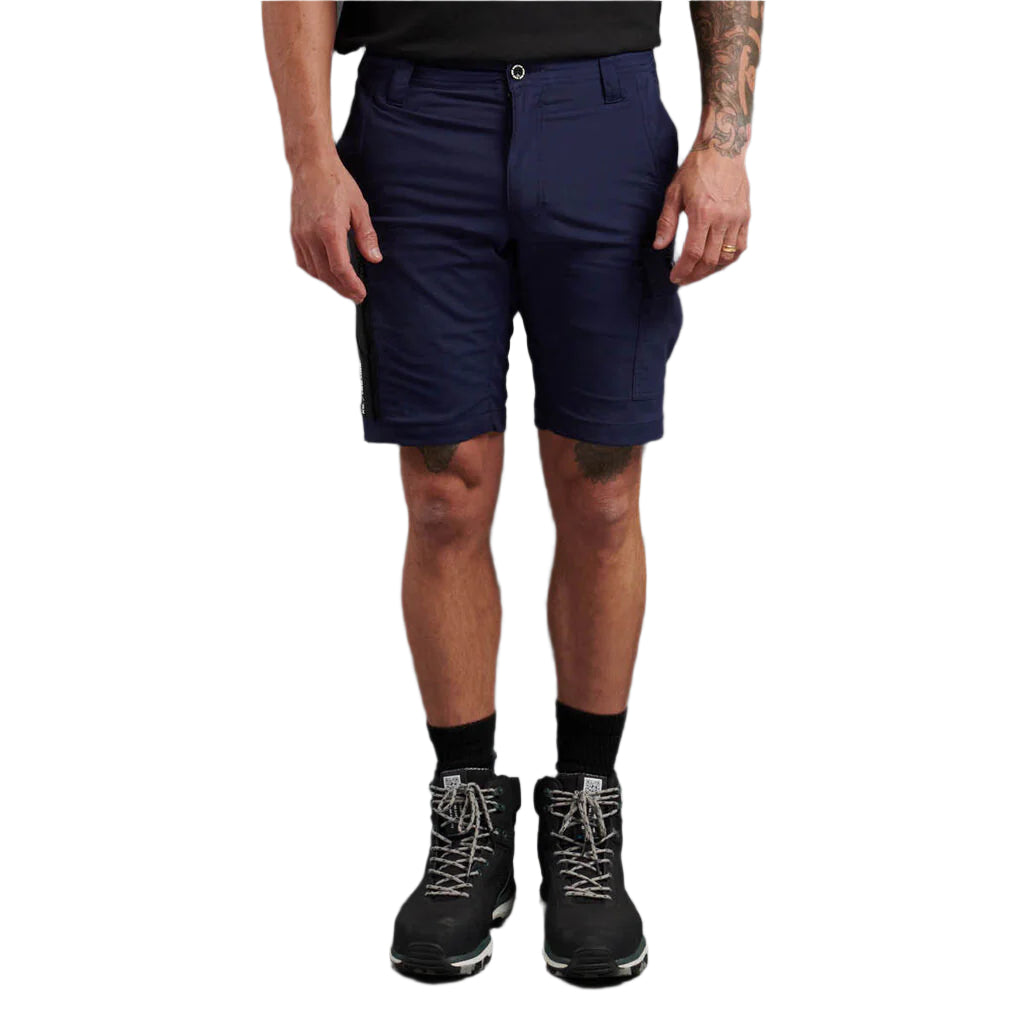 Person wearing navy shorts and black boots on a white background