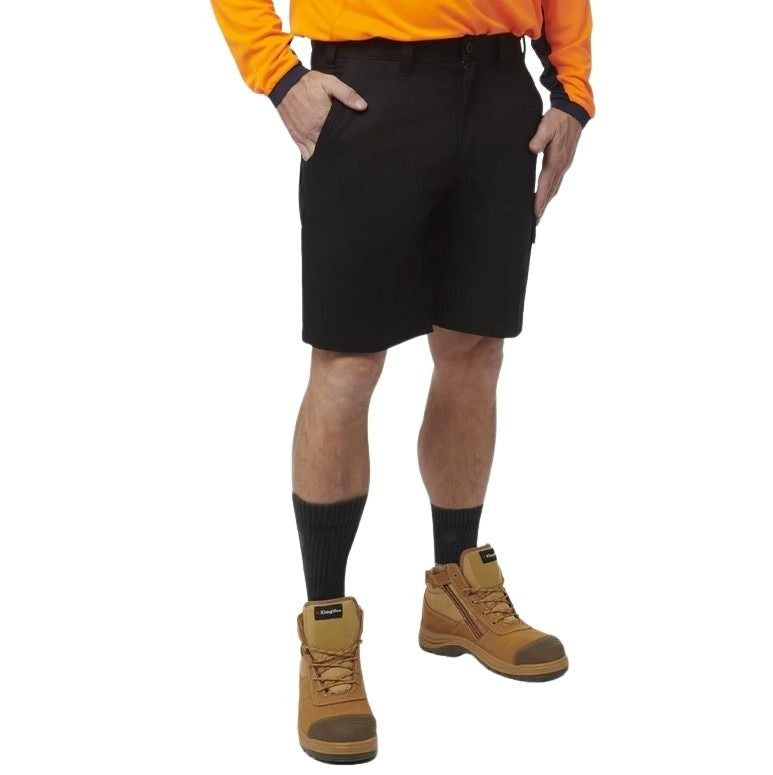 Person wearing black shorts, orange shirt, and brown boots on a white background