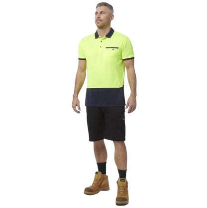 Man wearing a bright yellow and navy polo shirt with black shorts on a white background