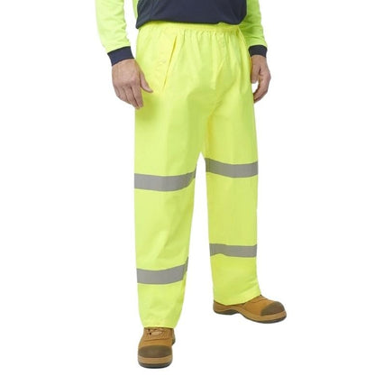 Person wearing high-visibility yellow pants with reflective stripes on a white background