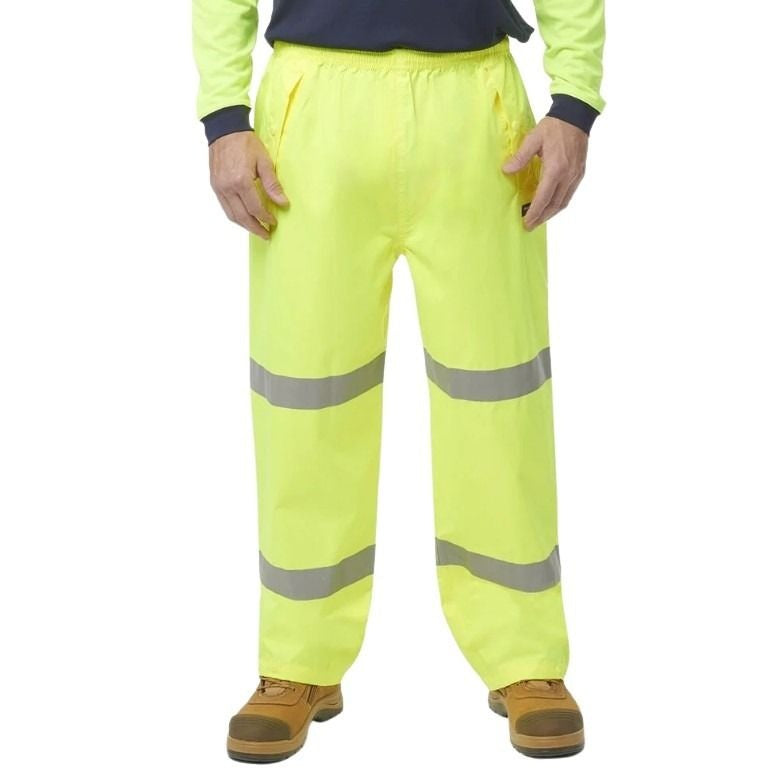 Person wearing high-visibility yellow work pants with reflective stripes on a white background
