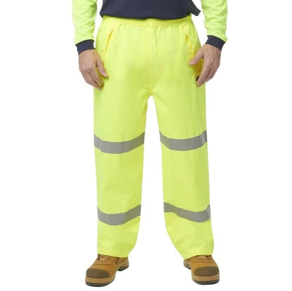 Person wearing high-visibility yellow work pants with reflective stripes on a white background