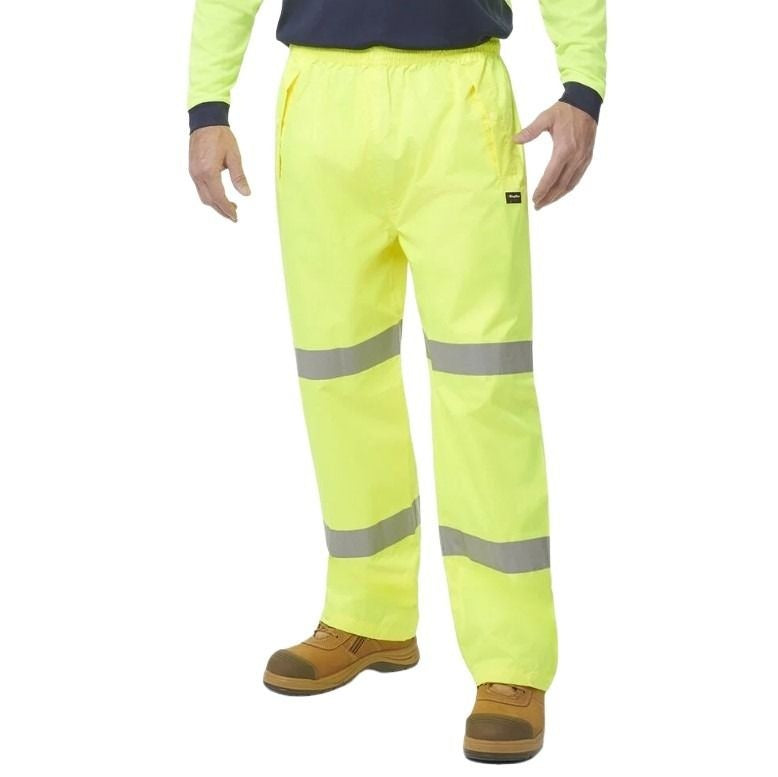 High-visibility yellow work pants with reflective stripes on a white background