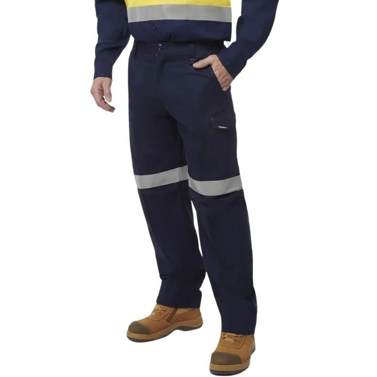 Person wearing navy work pants with reflective stripes on a white background