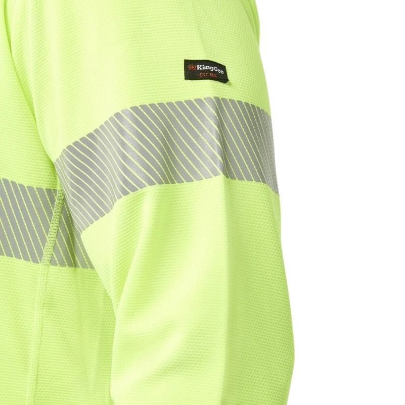 Close-up of a high-visibility green safety jacket with reflective stripes and a brand label.