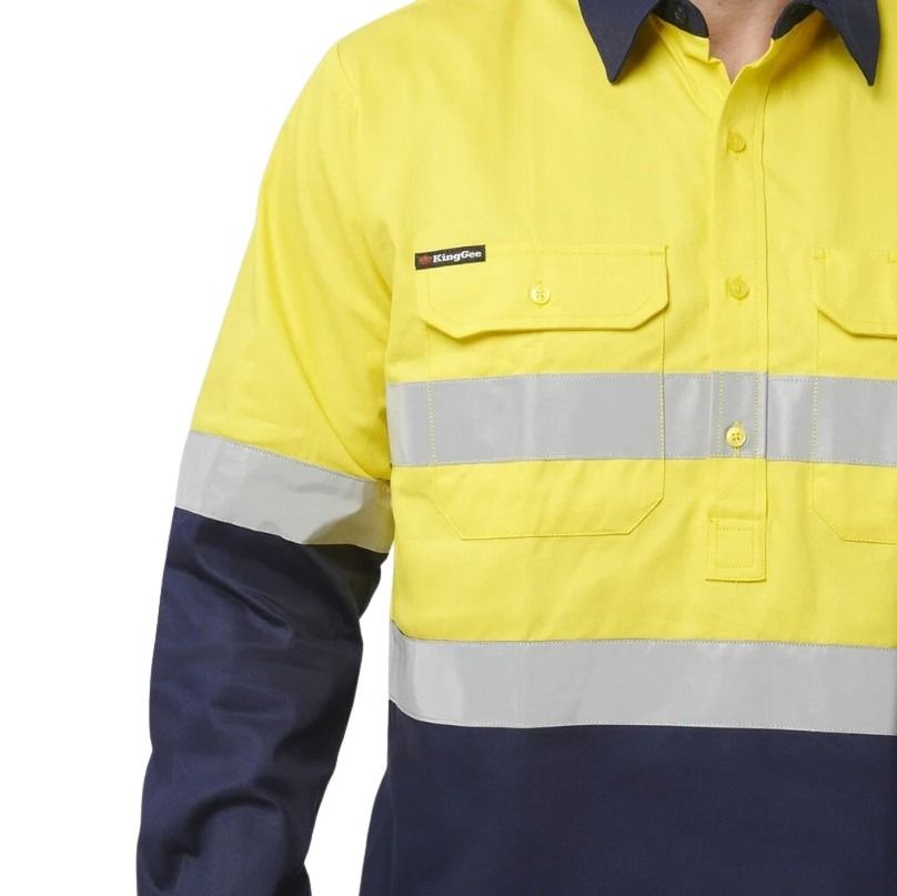 Man in Yellow spliced shirt with reflective tape brand name king gee on white background with two front pockets and half button placard