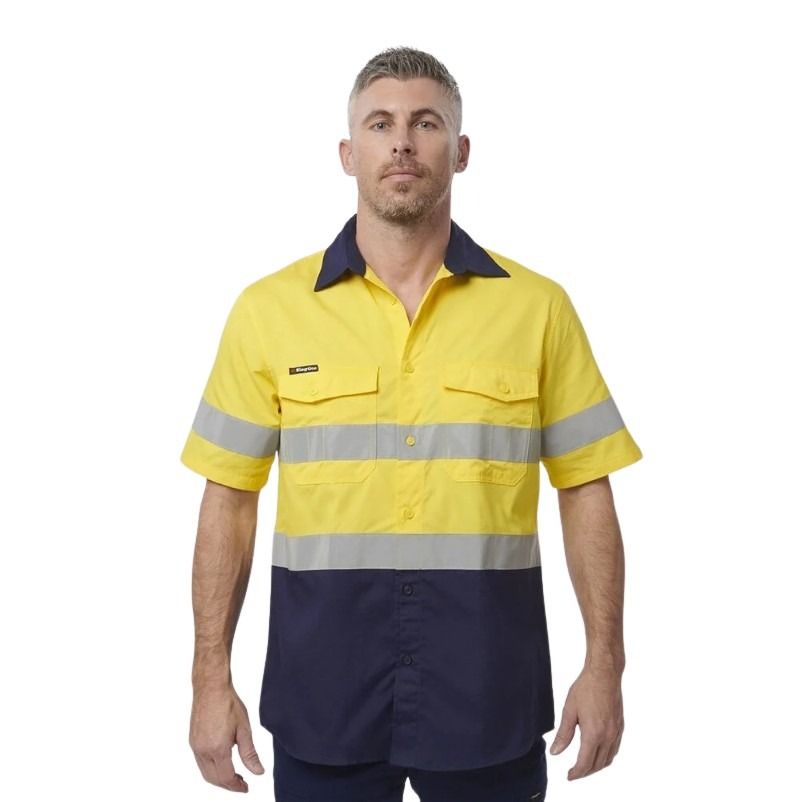 Man wearing a yellow and navy work shirt with reflective stripes on a white background