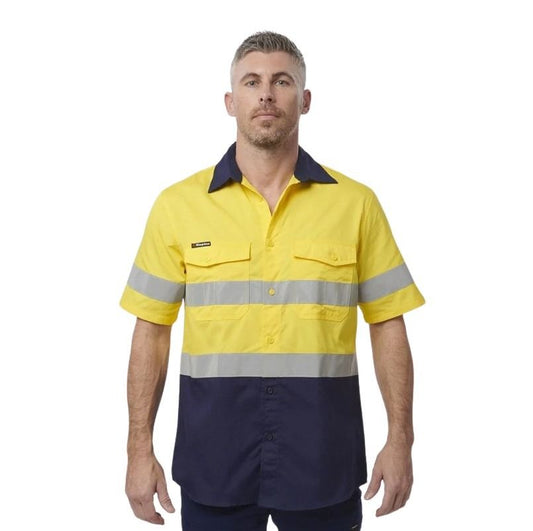 Man wearing a yellow and navy work shirt with reflective stripes on a white background