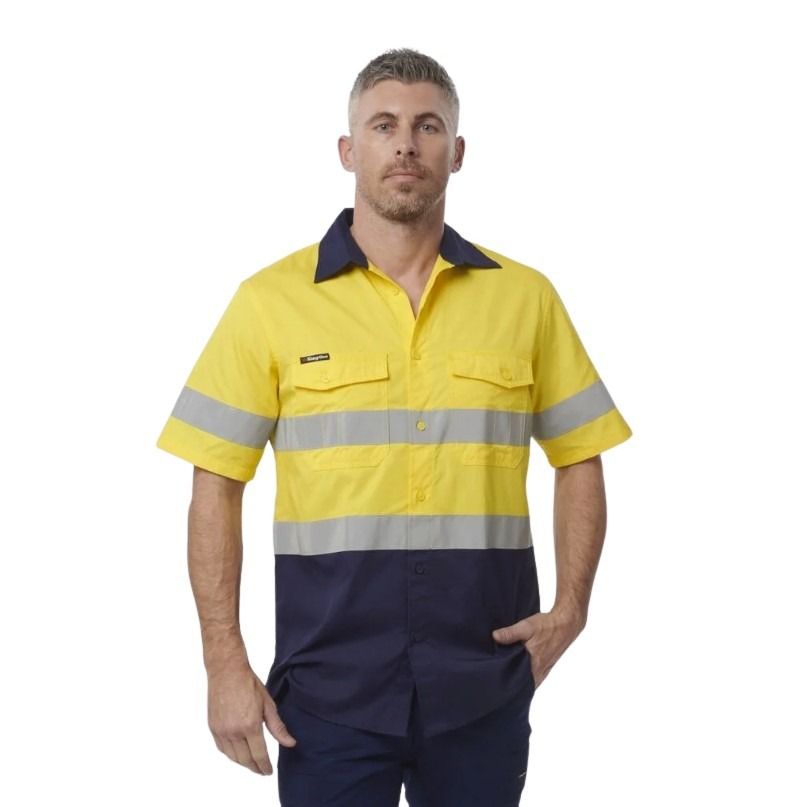 Person wearing a yellow and navy work shirt with reflective stripes on a white background