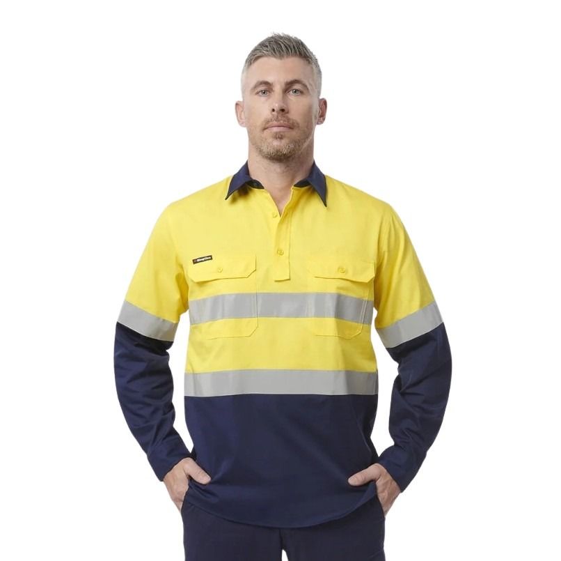 Man wearing a yellow and navy work shirt with reflective stripes on a white background