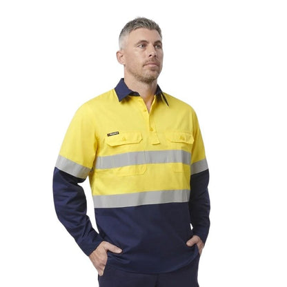 Man wearing a yellow and navy work shirt with reflective stripes on a white background