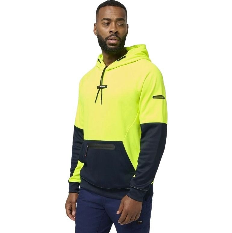 Man wearing a two-tone hoodie with bright yellow and navy design on a white background