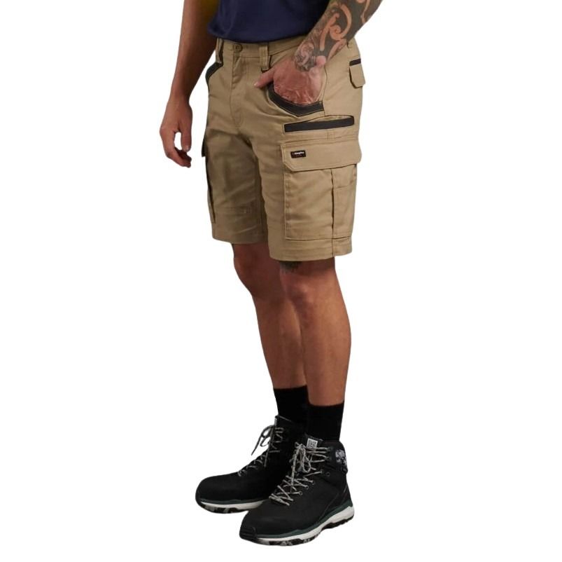 Person wearing tan cargo shorts and black hiking boots on a white background