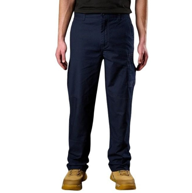 Person wearing navy pants and tan boots on a white background