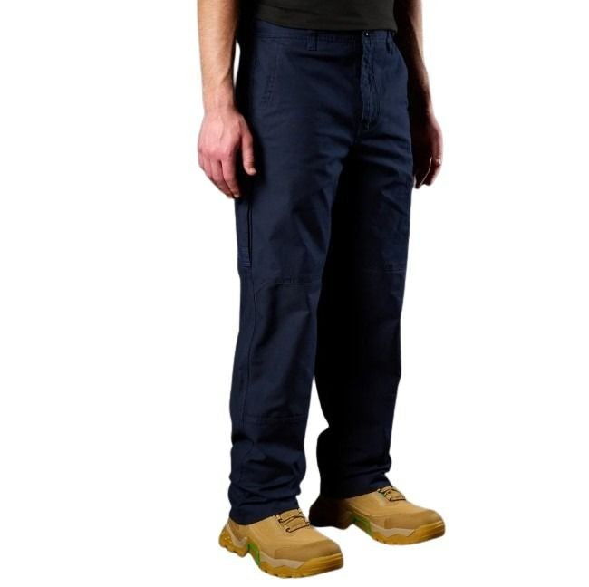 Person wearing navy blue pants and tan boots on a white background