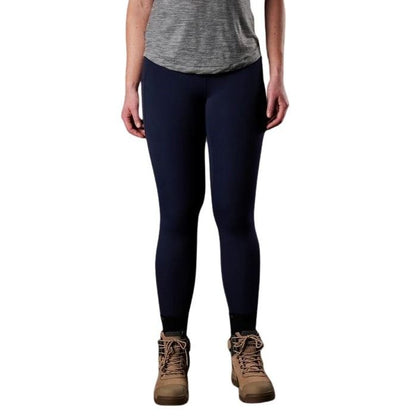 Person wearing navy leggings and brown boots on a white background