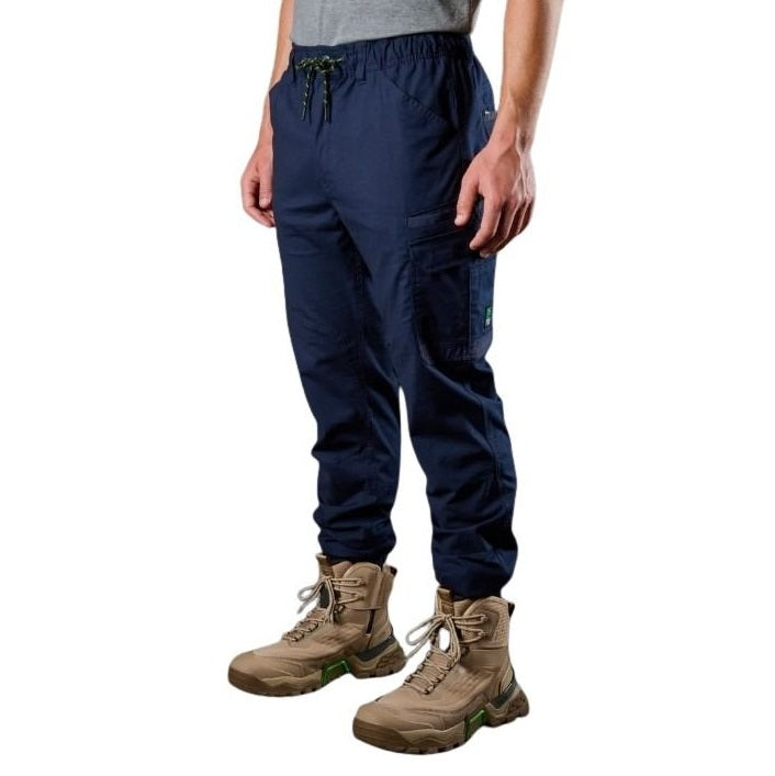 Person wearing navy cargo pants and brown boots on a white background