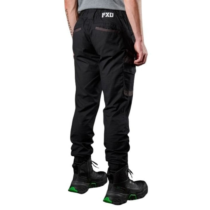 Person wearing black pants with FXD branding on a white background