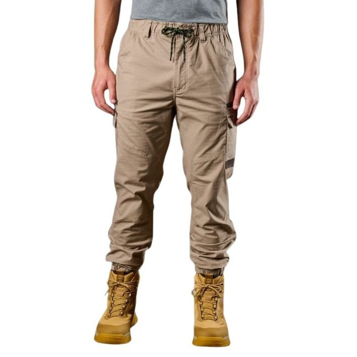 Person wearing beige cargo pants and yellow boots on a white background