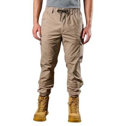Person wearing beige cargo pants and yellow boots on a white background