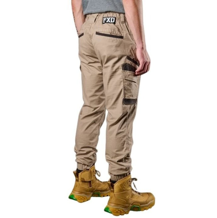 Person wearing beige cargo pants with visible branding on a white background